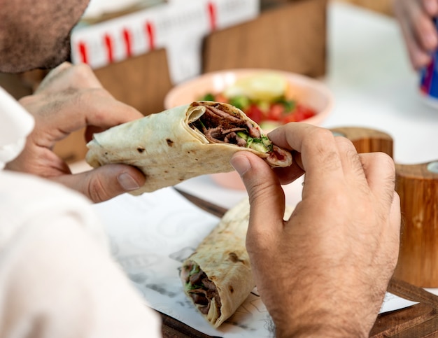 무료 사진 flatbread에 싸여 쇠고기 햄버거를 들고 남자