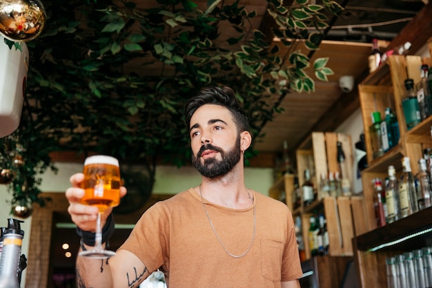 Free photo man holding beer in bar