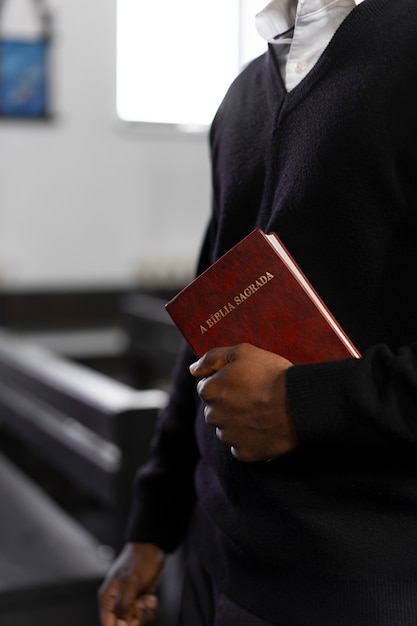 Мужчина держит библейскую книгу в церкви