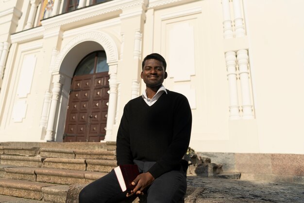 Man holding bible book outside the church