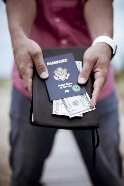 Foto gratuita uomo con bibbia denaro e passaporto