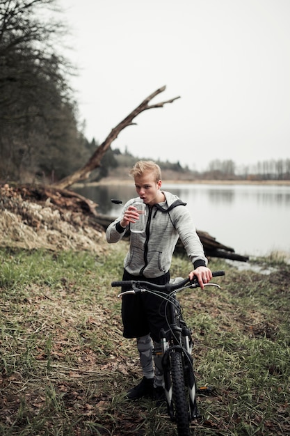 ボトルから自転車飲料水を持っている男