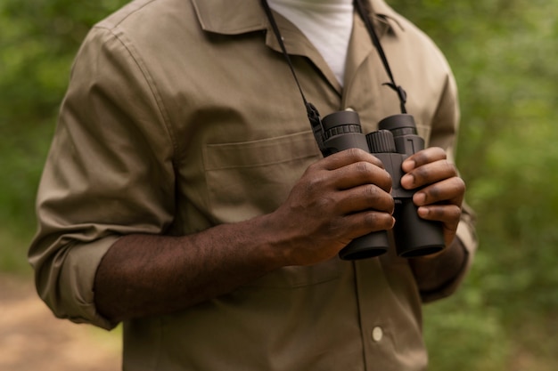 Free photo man holding binoculars side view