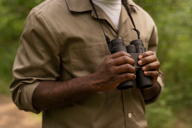 Man holding binoculars side view