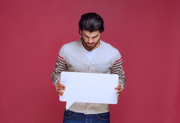 Free photo man holding a blank idea board and making presentation.