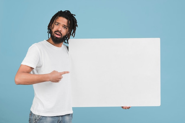 Free photo man holding a blank sign