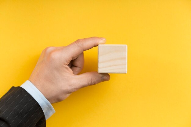 Man holding a blank wooden cube