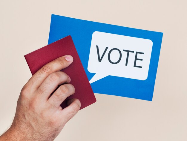 Man holding a blue card with voting speech bubble