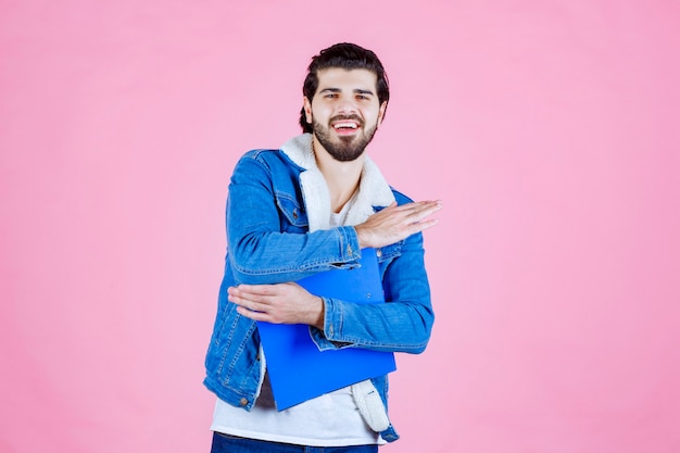 Free photo man holding a blue folder and looks positive