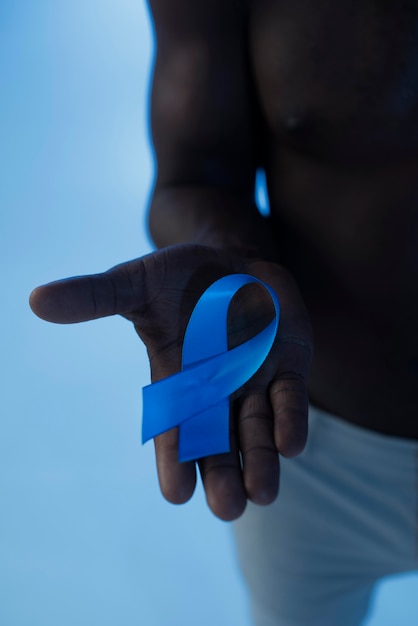 Free photo man holding a blue ribbon