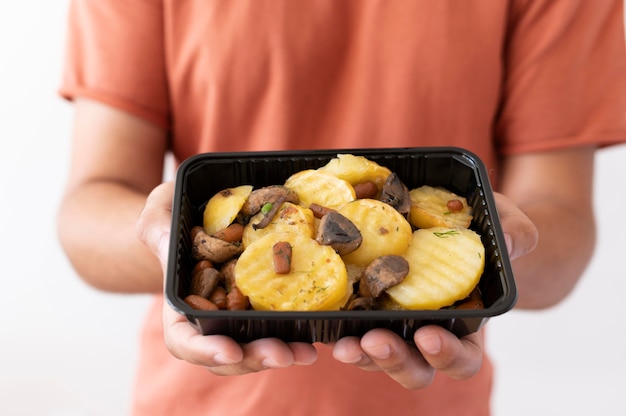 Foto gratuita uomo che tiene la scatola di cibo donato