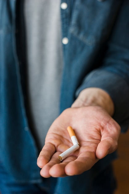 A man holding broken cigarette in his hand