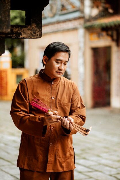 Man holding bundle of incense at the temple