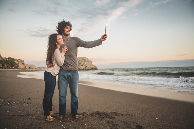 Man holding a burning flare while his bride smiles