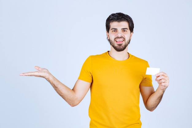 Man holding a business card and pointing at his partner.
