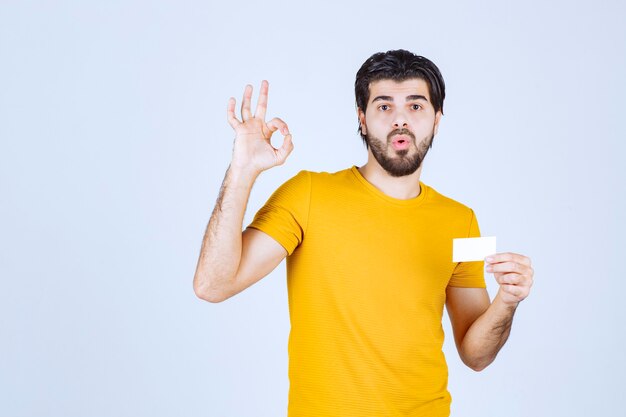 Man holding a business card and showing ok gesture