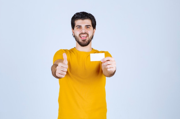 Man holding a business card and showing thumb up.