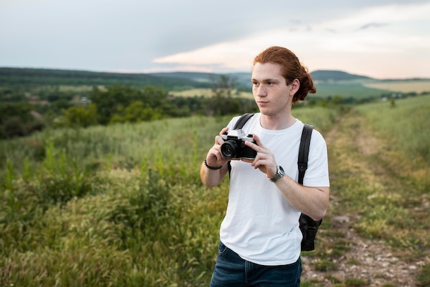 Free photo man holding camera medium shot