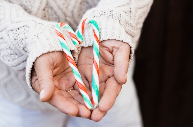 Free photo man holding candy canes in form of heart