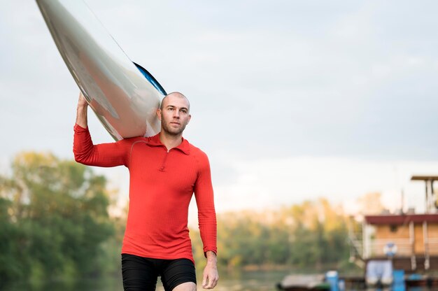 Man holding canoe on his shoulder