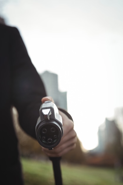 Man holding car charger at electric vehicle charging station