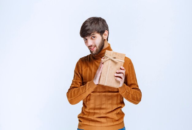 Man holding a cardboard gift box and presenting it to his girlfriend.