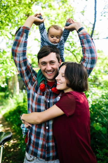 Man holding child getting hug from wife