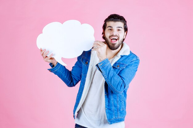 Man holding a cloud shape blank speech bubble and having fun.