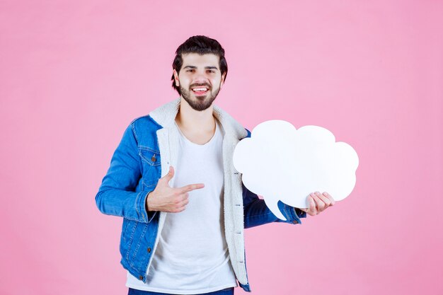 雲の形の空白のthinkboardを持って楽しんでいる男