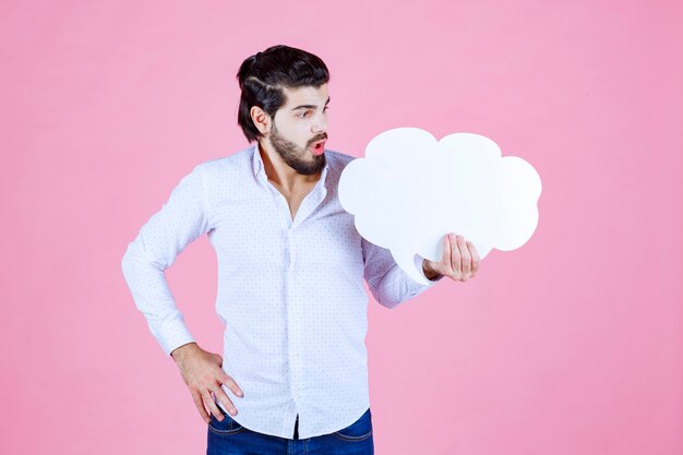 Man holding a cloud shape thinkboard and looks dissatisfied. 