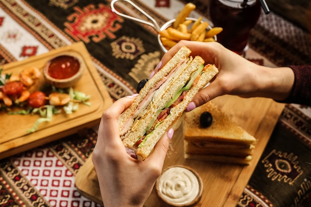 Free photo man holding club sandwich