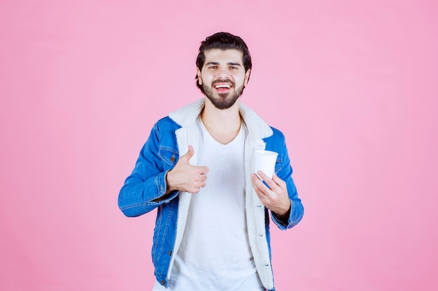 Man holding a coffee cup and enjoying the taste