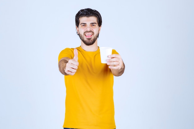 Man holding a coffee cup and enjoying the taste.