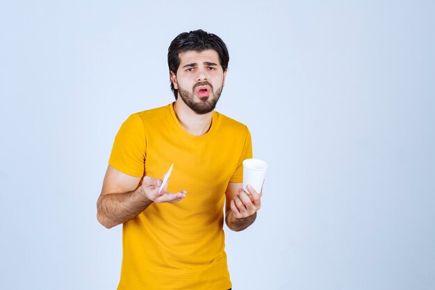 Man holding a coffee cup and looks dissatisfied.