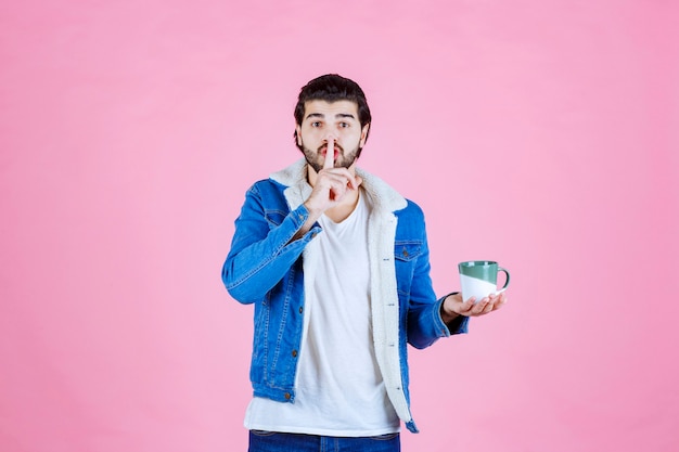 Free photo man holding a coffee cup and thinking