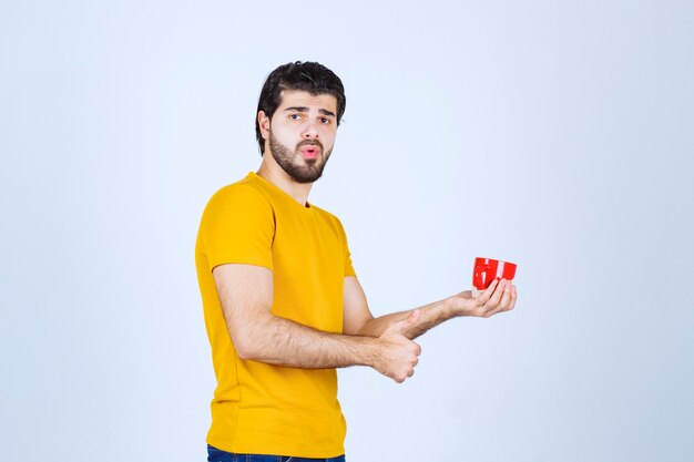 Man holding a coffee mug and enjoying the taste.