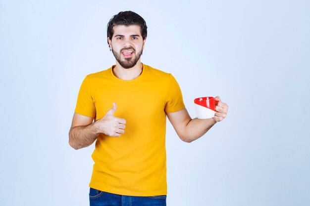 Man holding a coffee mug and enjoying the taste.