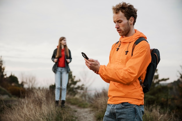 Man holding compass while on a road trip with girlfriend