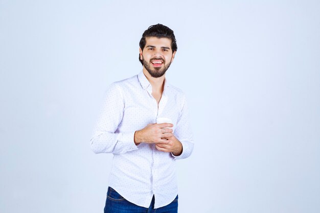 Man holding a cup of drink and feeling satisfied