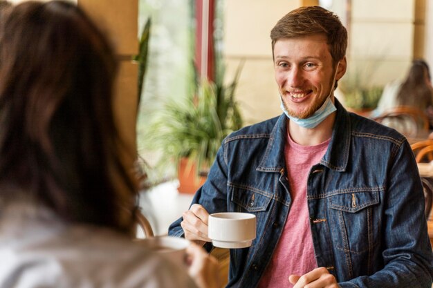 友達とお茶を持っている男