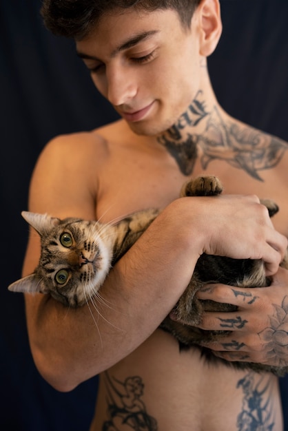 Foto gratuita uomo che tiene vista frontale del gatto carino