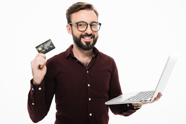 Man holding debit card and laptop computer.. shopping online