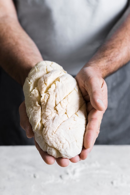 Man holding dough for bread front view