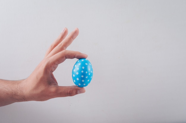 man holding an easter egg on white background.