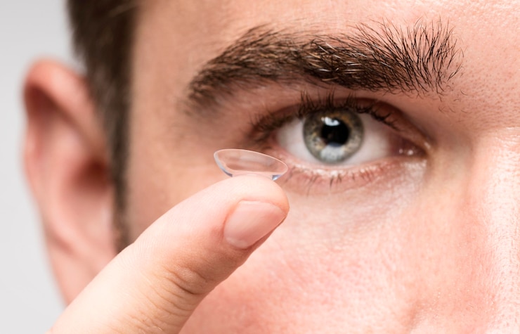 Free Photo man holding an eye contact