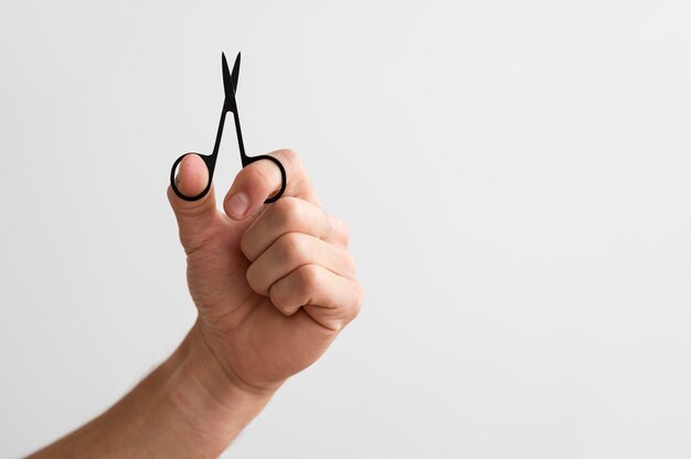 Man holding fingernails scissors with copy space