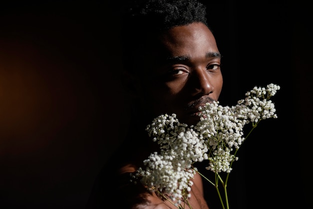 Free photo man holding flowers close-up