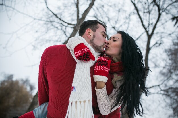 Man holding girl on back and kissing