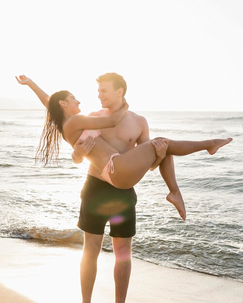 Man holding girlfriend at beach