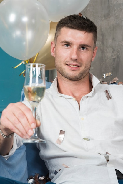 Free photo man holding glass of champagne